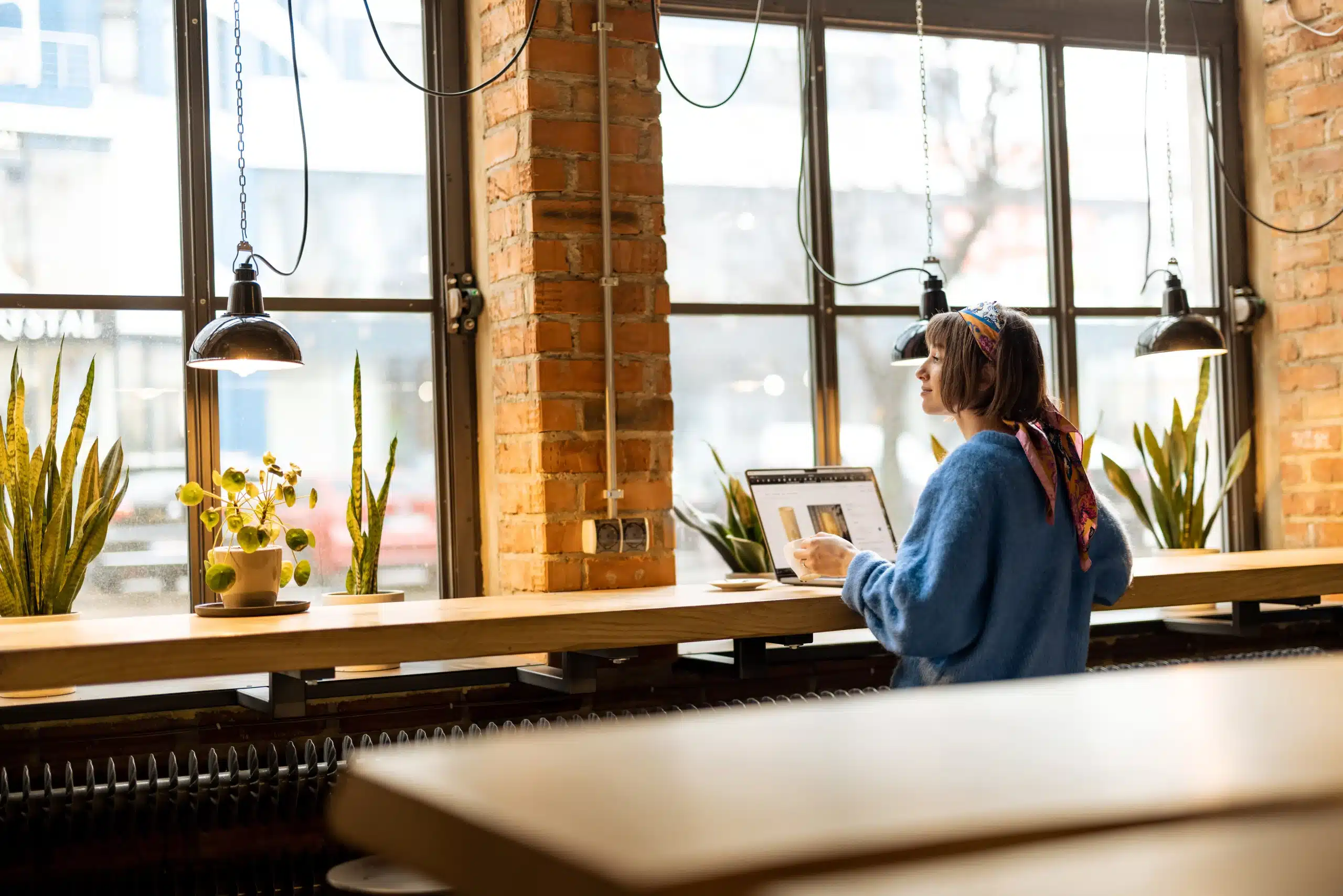 Woman working on a laptop in a bright workspace, representing modern blogging and digital content strategy.