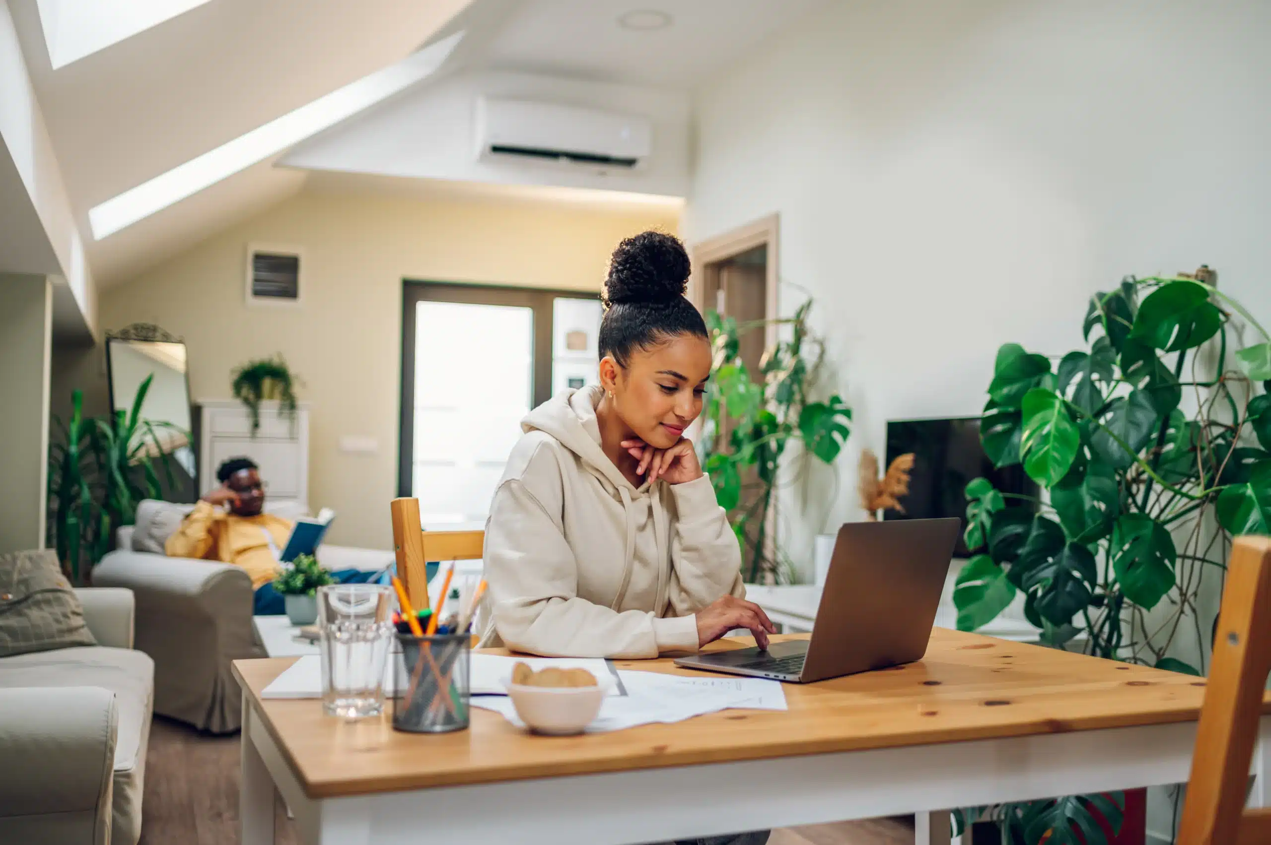 Portrait of a hispanic woman using laptop at home Hispanic woman using laptop while sitting at the table together at home. Female latino enjoying purchasing goods online in internet store. Online banking, paying bills and rent. Copy space.