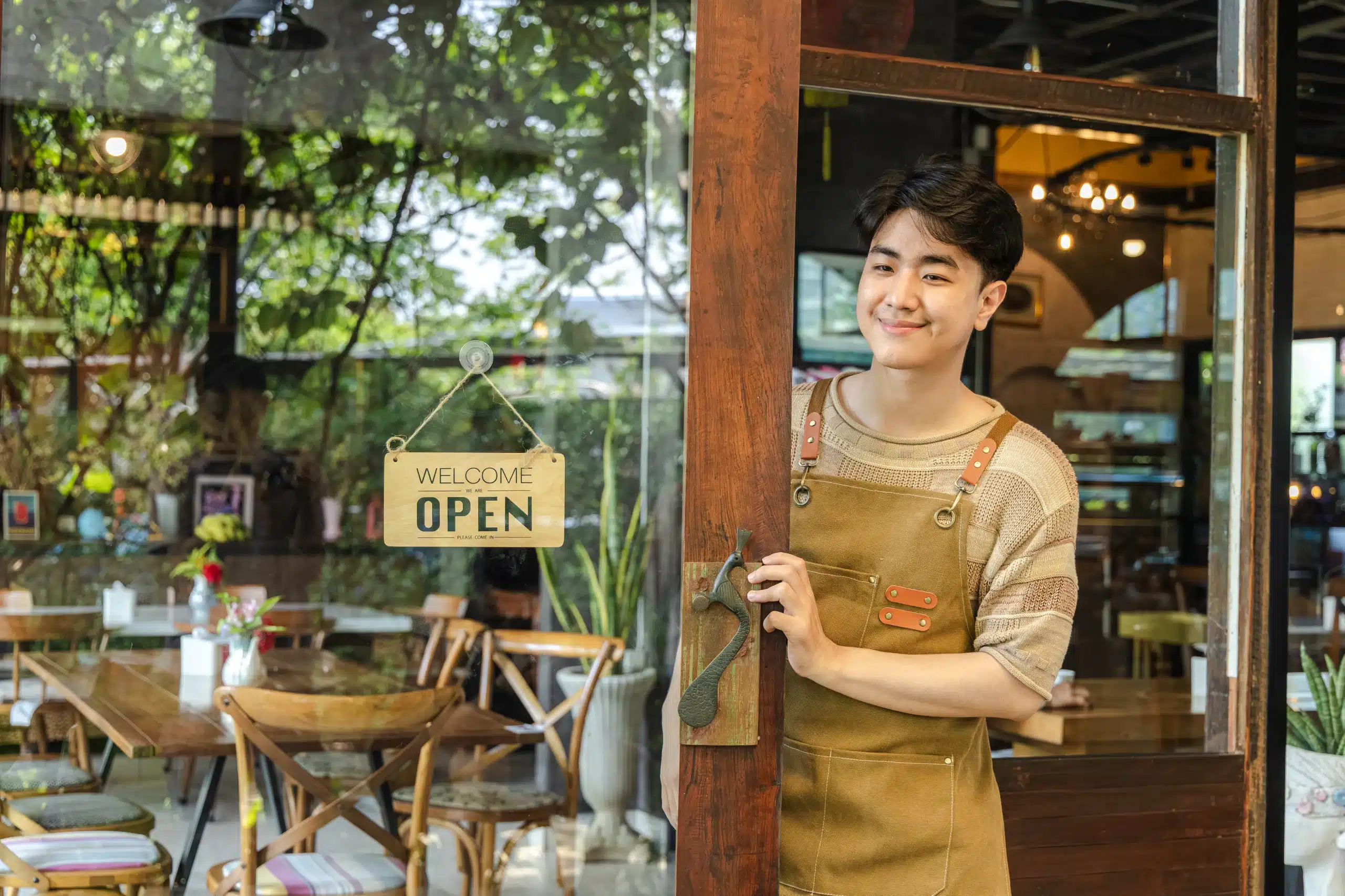 local-seo-small-business-open-sign A small business owner flipping the open sign at their storefront, representing how local SEO helps businesses get found by nearby customers
