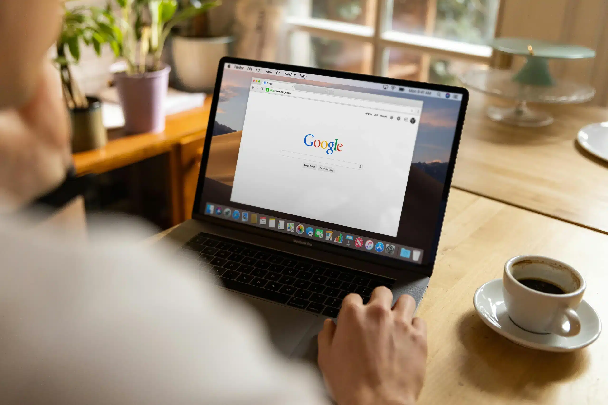 rank-google-without-big-budget A person browsing Google on a laptop with a coffee cup nearby, representing affordable SEO strategies for small businesses