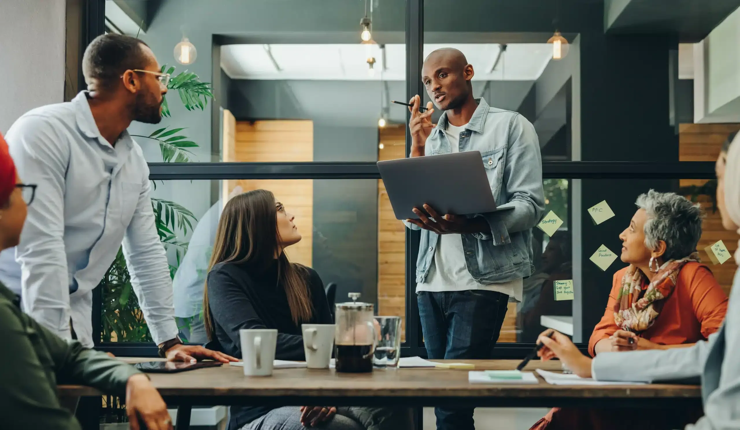 Diverse business team having a meeting in a creative workplace Diverse business professionals having a discussion during a meeting in a modern office. Team of multicultural businesspeople sharing creative ideas in an inclusive workplace.