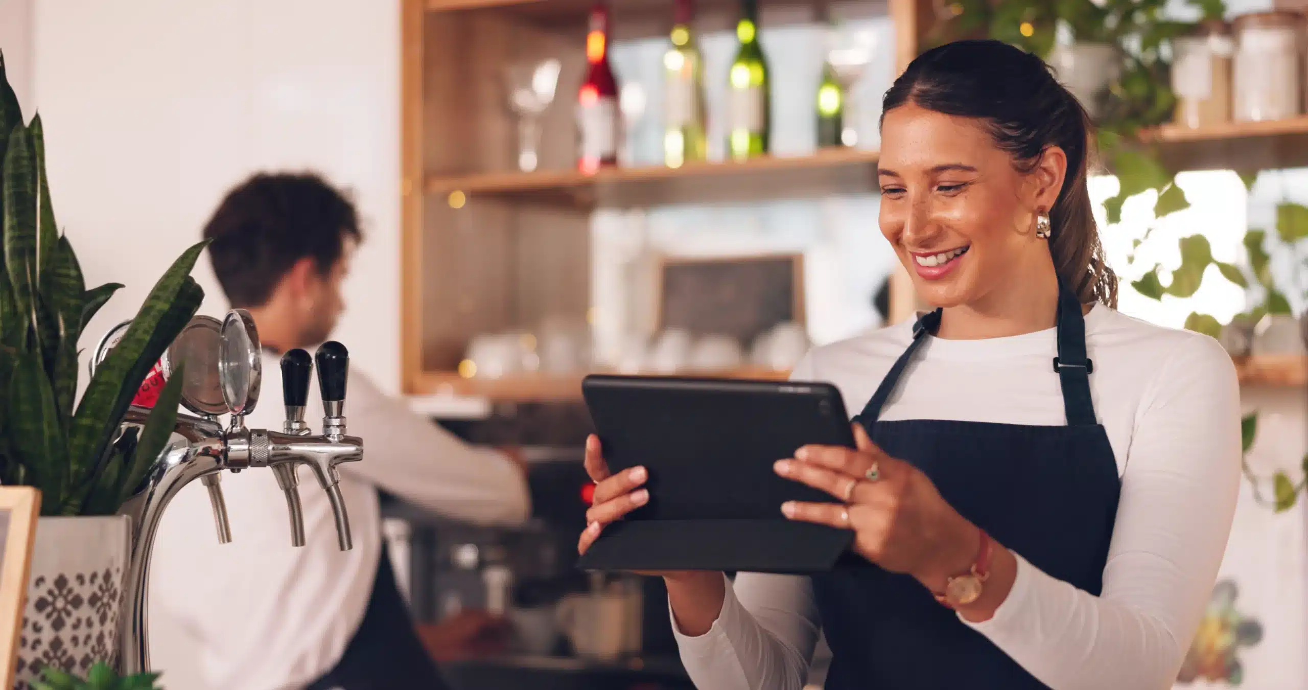 Social Media Management Small Business Owner A small business owner smiling while managing her social media on a tablet, representing practical social media management for growing businesses